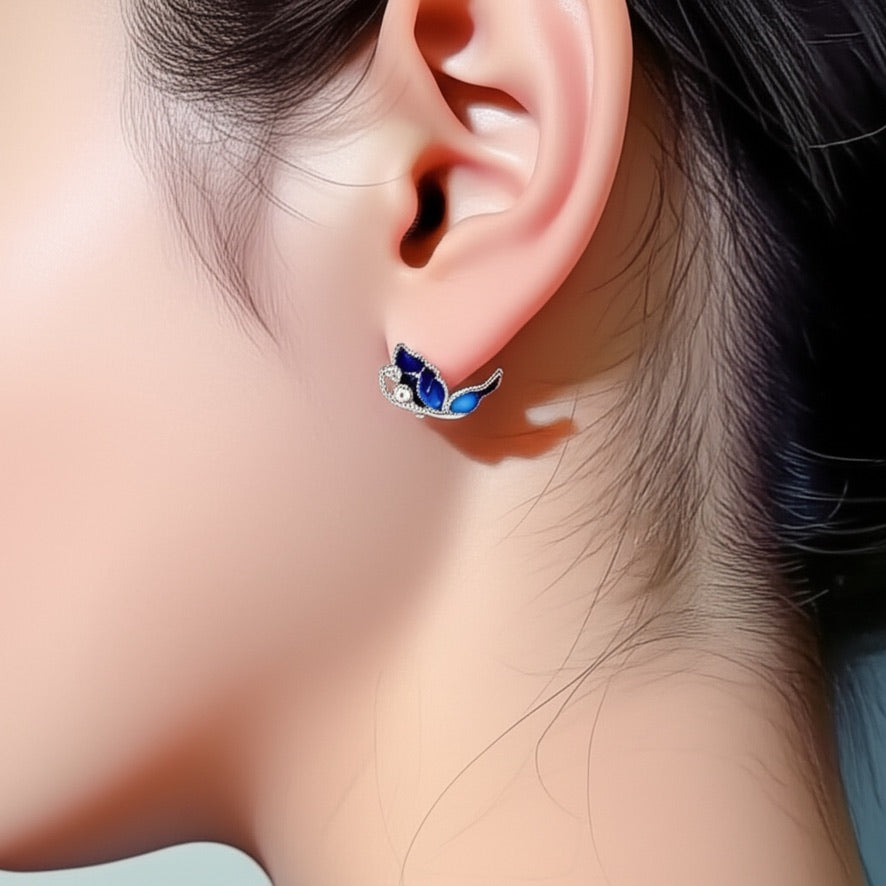 Woman wearing lightweight blue butterfly earrings in silver for a classic, everyday look