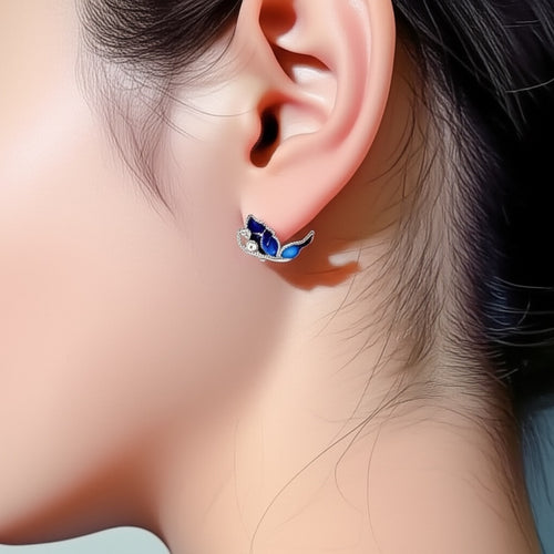 Woman wearing lightweight blue butterfly earrings in silver for a classic, everyday look