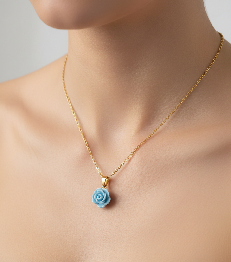 An elegant young woman wearing a necklace with a blue rose pendant on a gold chain against a white background