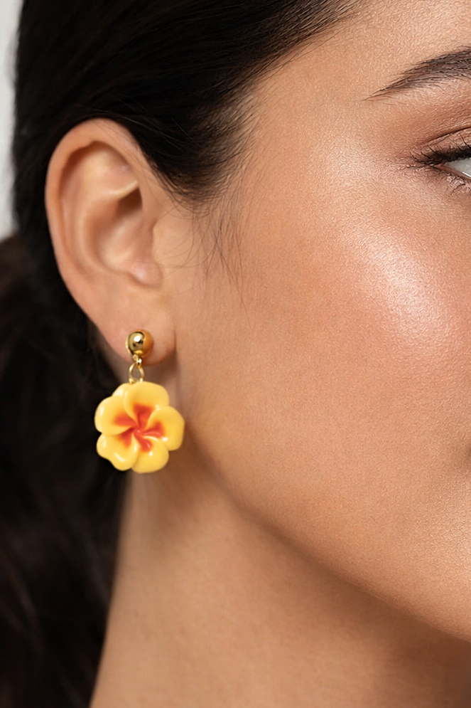 Close-up of a woman wearing a yellow floral earring