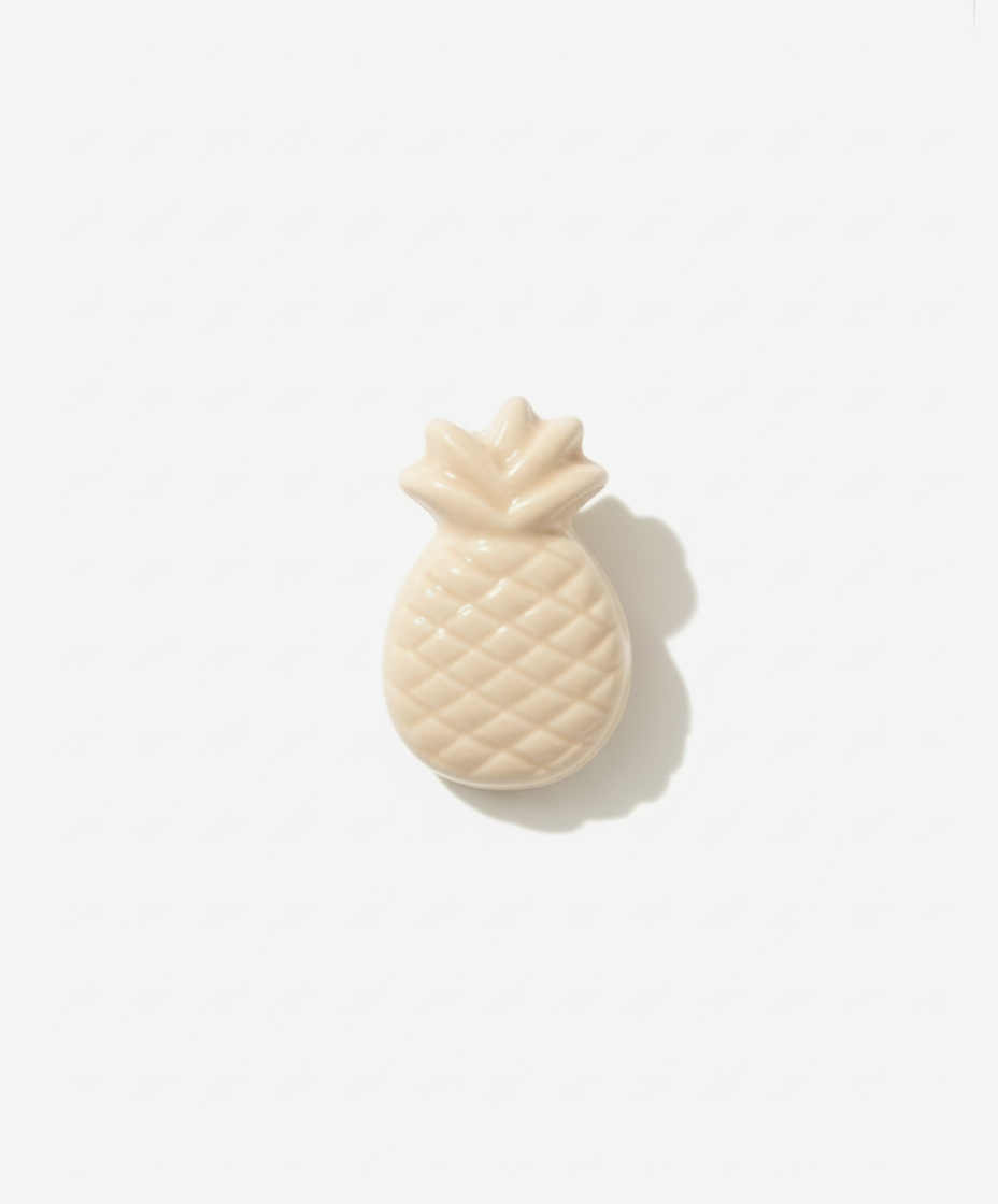 Light beige pineapple-shaped lapel pin brooch on a white background