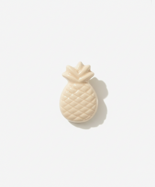 Light beige pineapple-shaped lapel pin brooch on a white background