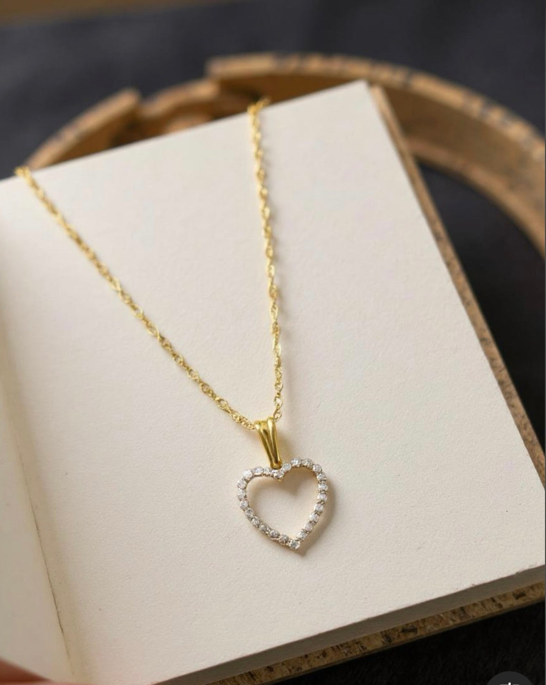 Gold heart-shaped necklace on a white box