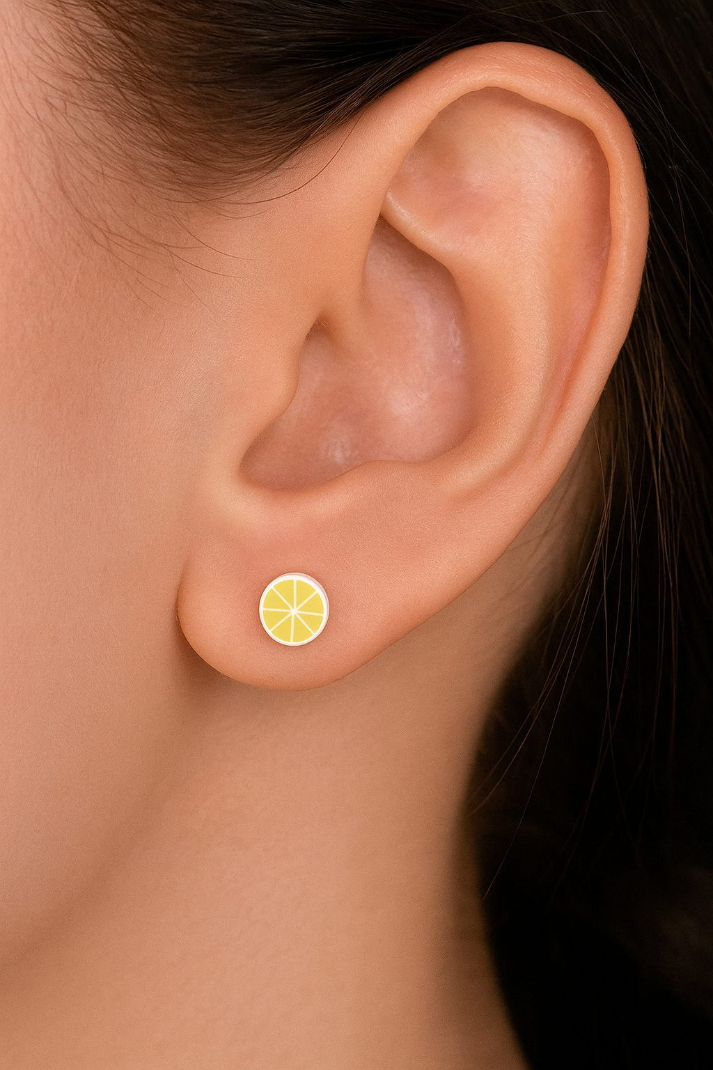 Close-up of an ear wearing a lemon slice earring.