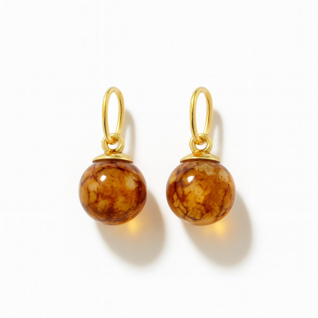 Pair of glass bead charms for earrings with golden elementsl on a white background