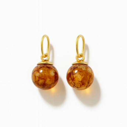 Pair of glass bead charms for earrings with golden elementsl on a white background