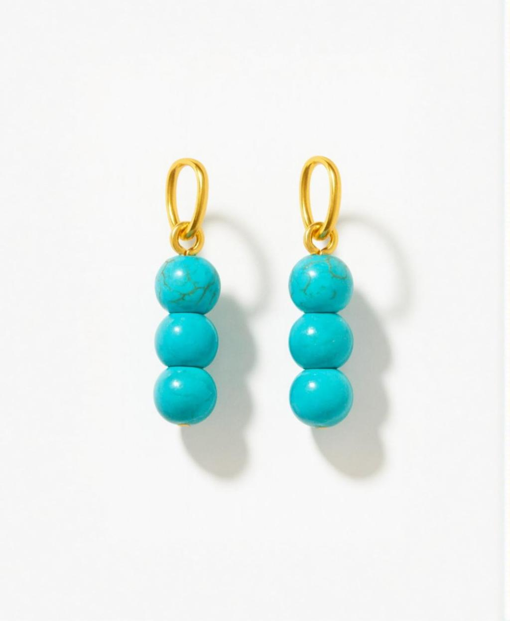Turquoise beaded charms for earrings with gold hooks on a white background