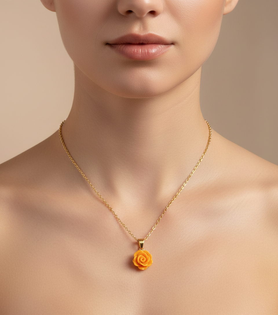 Gold necklace with a yellow rose pendant on a white background