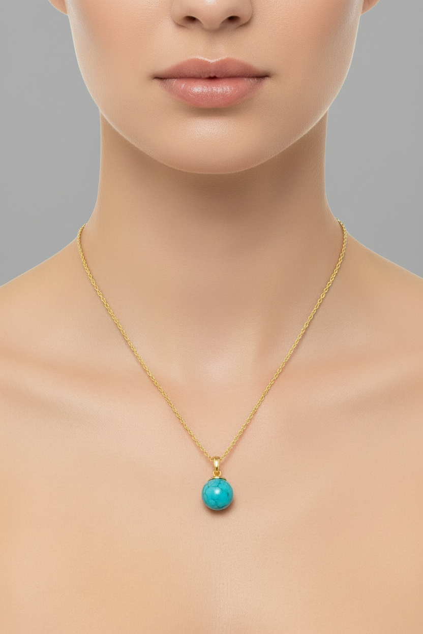 Turquoise pendant necklace on a gold chain against a white background
