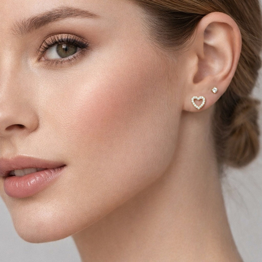 Close-up of a woman wearing heart-shaped earrings with a neutral background