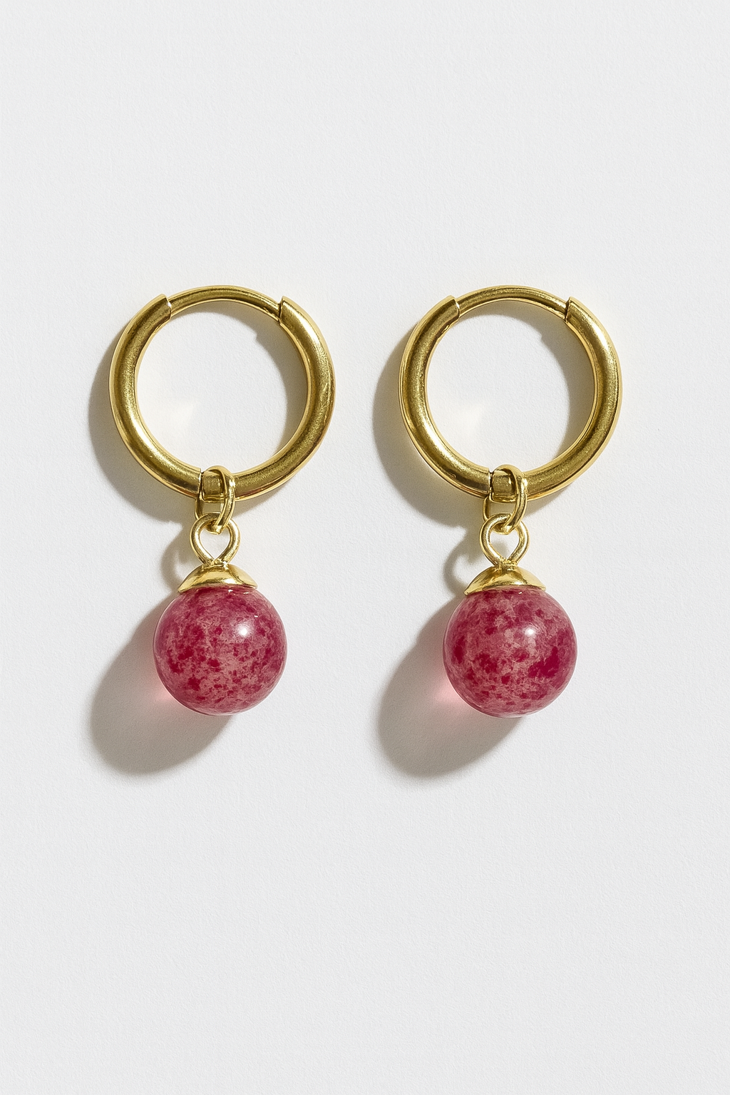 Gold hoop earrings with pink jade bead charms