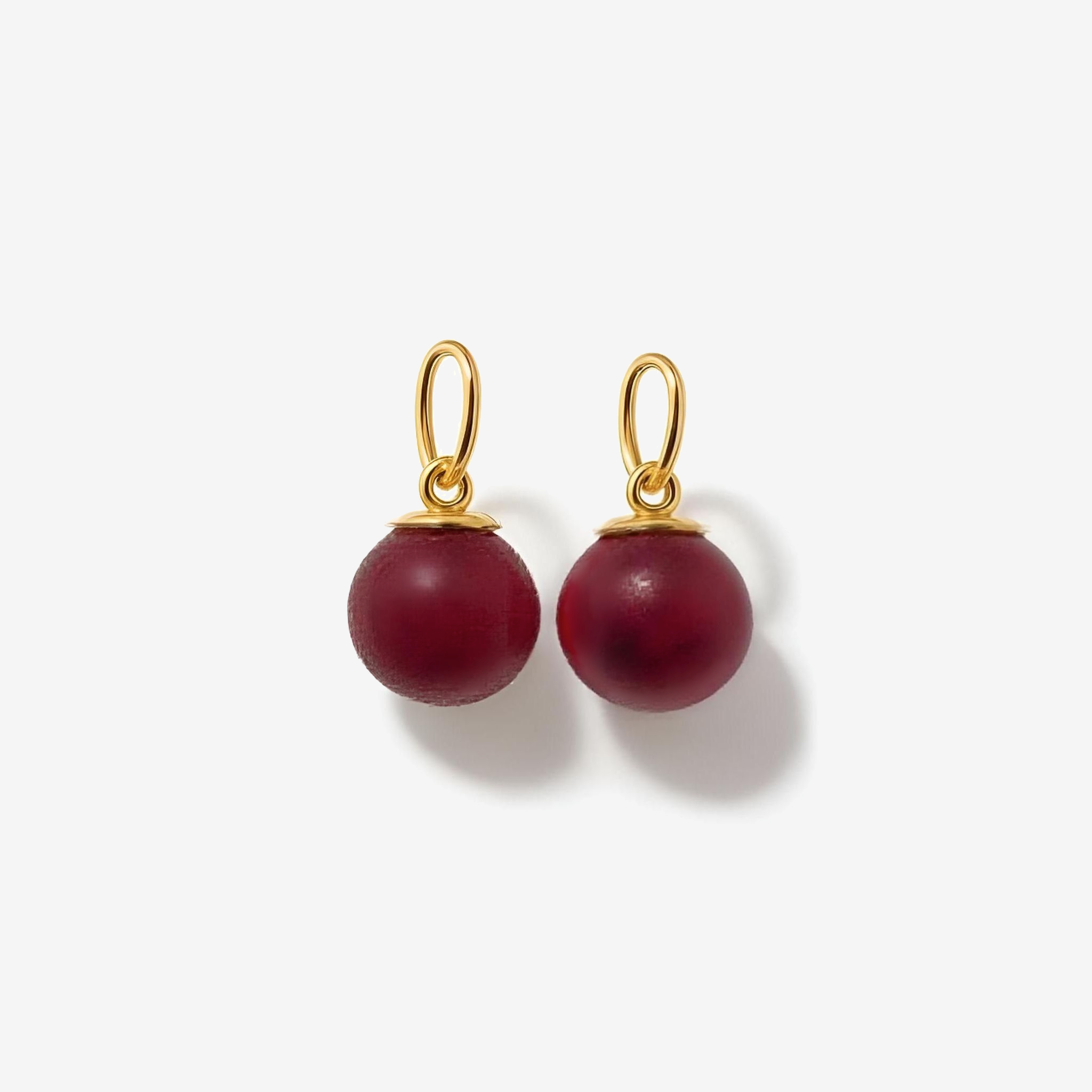 Pair of red beaded charms earrings with gold hooks on a white background
