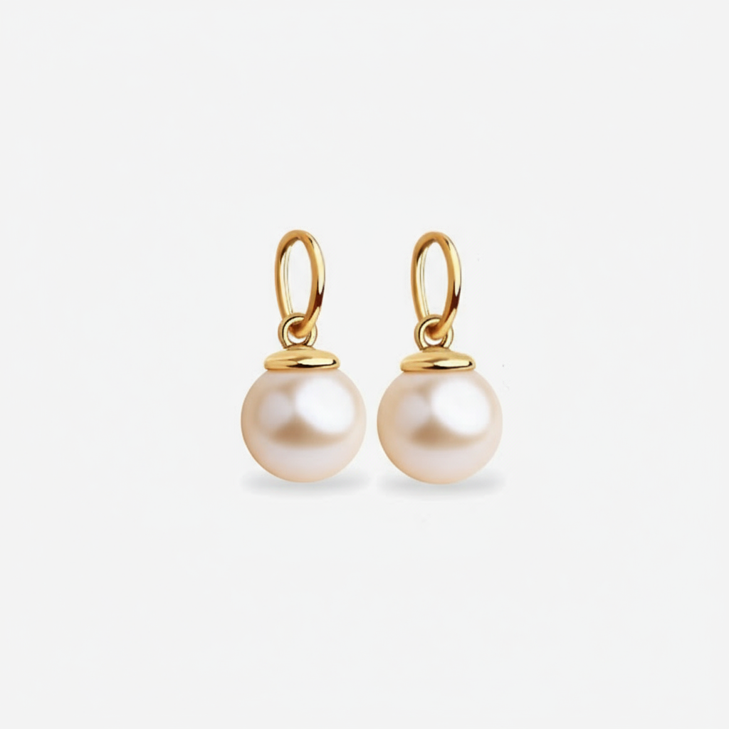 Pair of pearl dangle charms for earrings with gold hooks on a light gray background