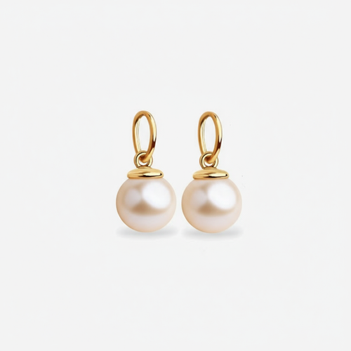 Pair of pearl dangle charms for earrings with gold hooks on a light gray background